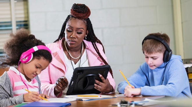 leerkracht helpt kinderen met dyslexie op school
